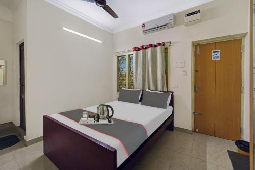 钦奈Collection O Arn Guest House Near Chennai International Airport的一间卧室,配有一张带奖杯的床