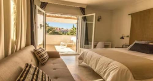 贝纳尔马德纳espectacular villa puerto marina playa的一间带大床的卧室和一个阳台