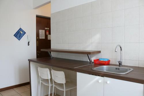 科尔西科博弈特撒公寓的厨房配有水槽和2张白色凳子