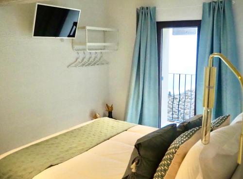 坎德拉里奥La Casa Rebonita PICCOLA的卧室配有一张床铺,墙上配有电视