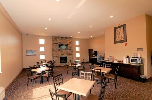 DenisonCobblestone Inn & Suites - Denison | Oak Ridge的一间带桌椅和壁炉的用餐室