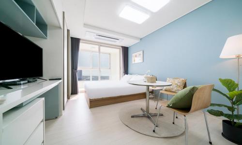 仁川市Urbanstay Songdo Moonlight Park的一间卧室配有一张床、一张桌子和一台电视。
