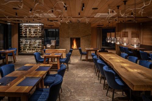 维特科维采Aldrov Resort的餐厅设有木桌、椅子和壁炉