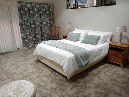 温特顿Drakenzicht Mountain Cottage的一间卧室配有带白色床单和枕头的床。