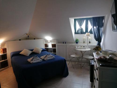 努奥罗Coros的一间卧室配有一张带蓝色床单的床和一张桌子。