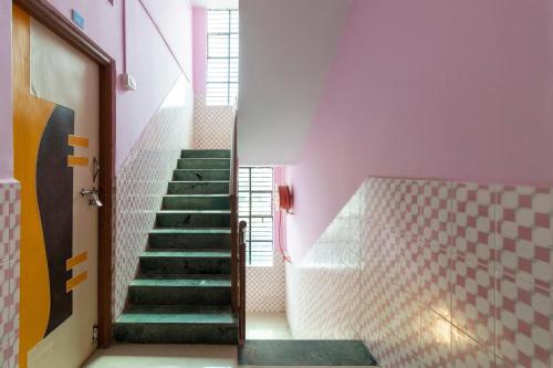 奥兰加巴德SPOT ON Shree Gajanan的粉红色墙壁的房间里,有绿色台阶的楼梯