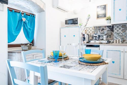 奥斯图尼Vico di Ostuni Apartments by Rentbeat的厨房配有白色的桌子和蓝色的椅子