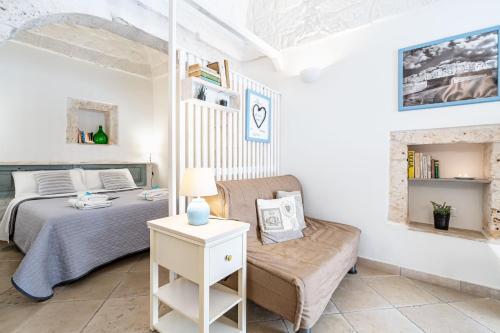 奥斯图尼Vico di Ostuni Apartments by Rentbeat的一间卧室配有一张床和一张沙发