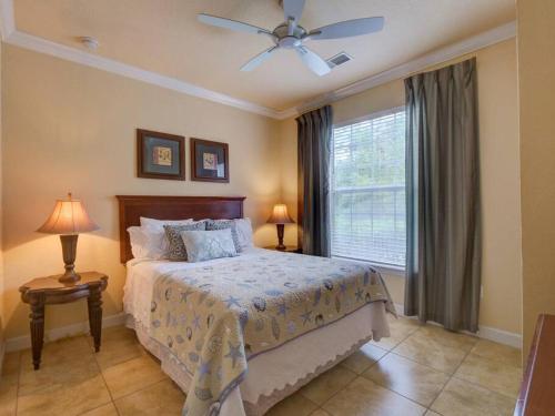 基西米Disney Memories at Tuscana Resort的一间卧室配有一张带吊扇和窗户的床。
