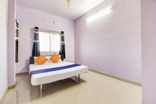 BhandāraSPOT ON The Highway Inn的一间卧室配有带橙色和蓝色枕头的床
