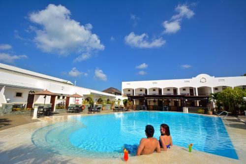 邦劳邦劳摄政公园度假酒店的两人坐在度假村的游泳池里