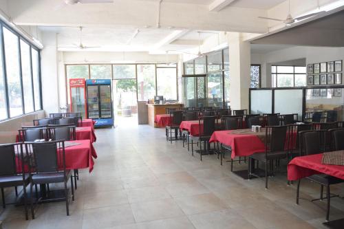 舍地HOTEL SAI PALKHI NIWARA的一间设有红色桌椅的用餐室