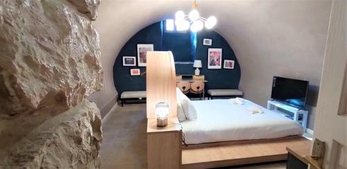 耶路撒冷Mina Boutique的一间卧室设有一张床和一面岩石墙