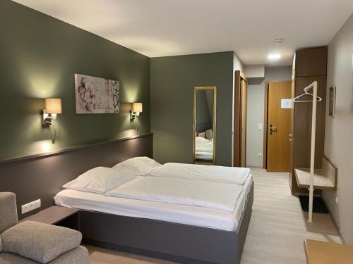 舍姆贝克祖尔姆勒餐厅及酒店的一间卧室设有一张大床和绿色的墙壁