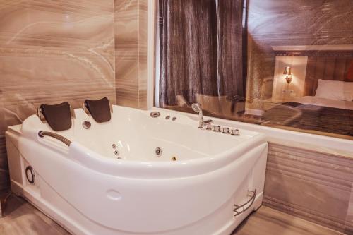 普里兹伦Nafron Hotel的带浴缸的浴室和床