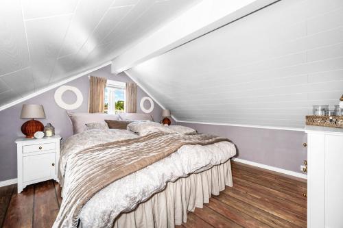 阿伦达尔Båthus med egen stor brygge og alle fasiliteter的阁楼上的卧室配有一张大床