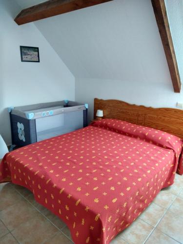 拉萨尔韦塔Séjour dans un cadre verdoyant的一间卧室配有一张红色棉被的床