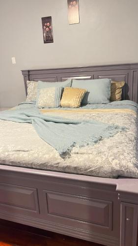 乔治敦Odyssey Suites的一张带木制床头板和枕头的床