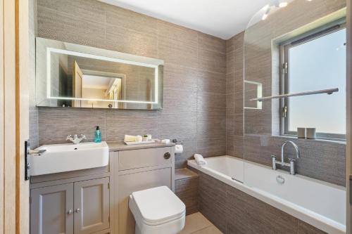 桑德斯富特Oaktree Lodge - Luxury Cottage, Hot Tub, Sea Views的带浴缸、盥洗盆和卫生间的浴室