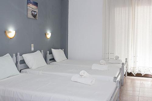 斯基亚索斯镇La Pensione Skiathos的客房内的三张床和白色毛巾