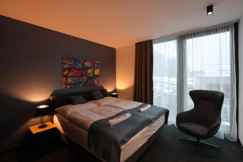 布拉迪斯拉发Ponton Rooms的卧室配有床、椅子和窗户。