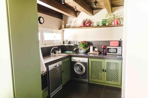 UrXalet Montana的厨房配有绿色橱柜和洗衣机。