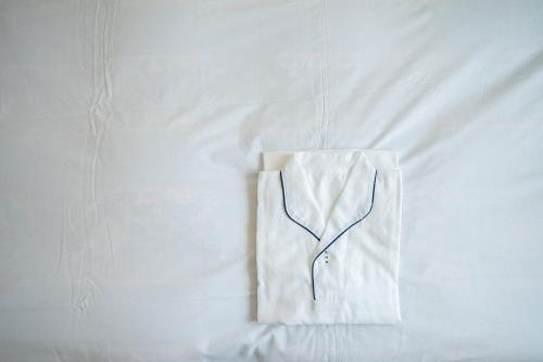 神户Hotel Casabella Inn Kobe的白色的衬衫挂在白色的床上