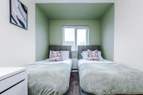 曼彻斯特Chic 2 Bed House with Garden & Free Parking的绿墙客房内的两张床