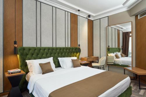 佩雷亚塞萨洛尼基皇家酒店的一间卧室配有一张大床和绿色床头板