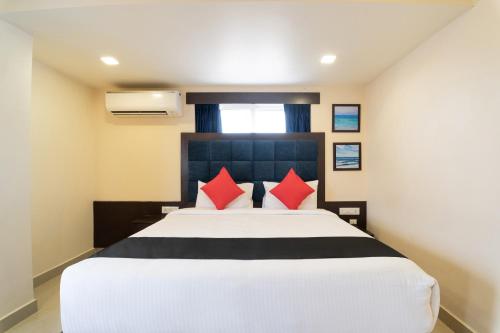 Raspari PalaoHotel Seatree的一间卧室配有一张带红色枕头的大床