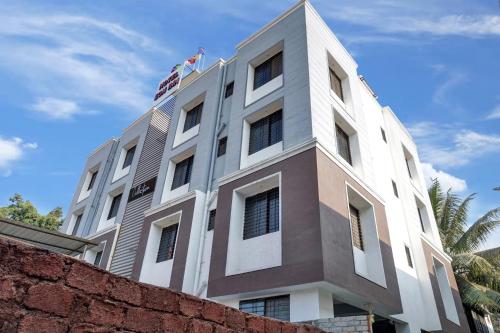 KharadiHotel Eon Inn Near Pune Airport的上面有旗帜的建筑