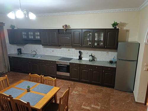 MantoúkionSavvas&Katia's luxury house的厨房配有黑色橱柜、桌子和冰箱。