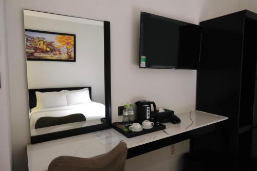 胡志明市Nicecy Boutique Hotel的酒店客房,配有床和镜子