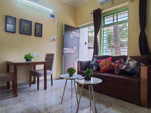 孟买OSI Apartments Khar West的客厅配有沙发和桌子