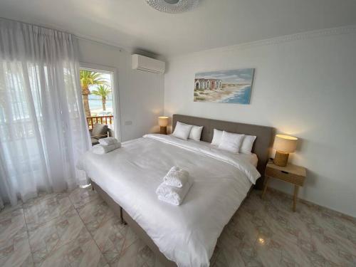 阿德耶Villa Tranquila, Playa del Duque的窗户客房内的一张大白色床