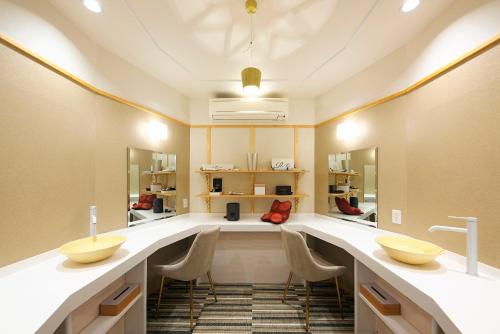 笛吹市甲子园铭庭日式旅馆的更衣室设有2个盥洗盆和镜子