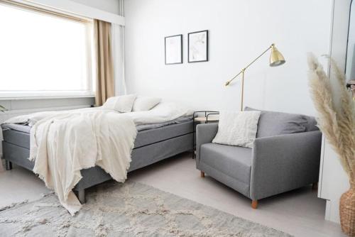 埃斯波Lovely studio in Leppävaara的一间卧室配有一张床、一张沙发和一把椅子