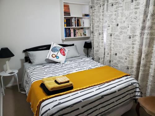 吉朗Gateway to the Surf Coast and Geelong的小卧室配有一张带黄白色毯子的床