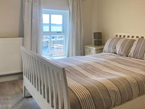 朗德斯通Cottage 170 - Roundstone的一间卧室设有一张大床和一个窗户。