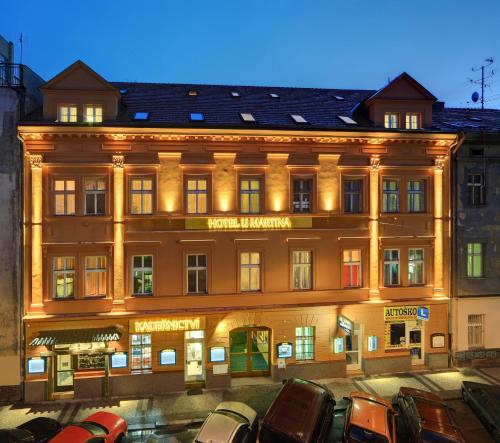 布拉格Martin Hotel Prague的一座大型建筑,前面有汽车停放