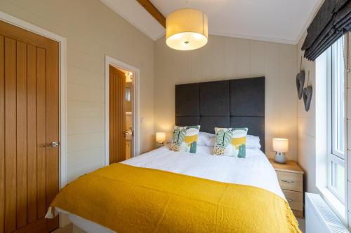 温德米尔Lakeside 4 Lodge的一间卧室配有一张带黄色毯子的大床