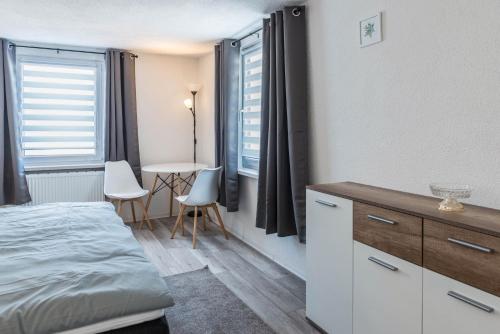 KrauchenwiesMina的一间卧室配有一张床和一张桌子及椅子