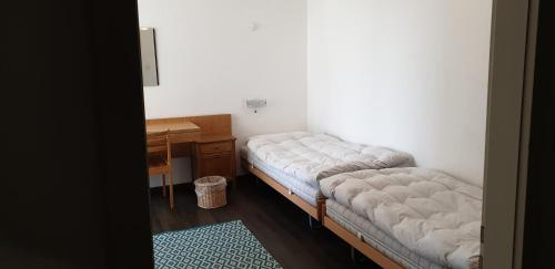 伦策海德Ferienwohnungen Chesa Clois 24的客房设有两张床、一张桌子和一张书桌。