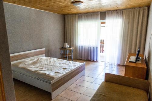 奥克宁卡Willa Magda的一间卧室配有一张床、一张沙发和一个窗口