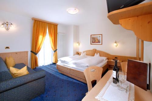 塞尔瓦迪加尔代纳山谷Hotel Else的酒店客房,配有床和沙发