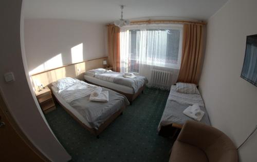 科尔别卢夫Ośrodek Wypoczynkowy Diuna Beskidy的酒店客房设有两张床和窗户。
