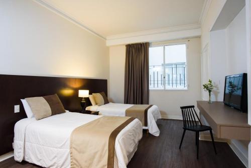 布宜诺斯艾利斯1253 Recoleta Small Hotel的酒店客房设有两张床和电视。