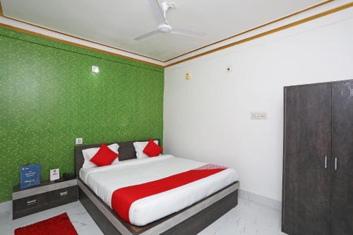 布巴内什瓦尔OYO Aradhya Residency的一间卧室配有一张带绿色墙壁的床