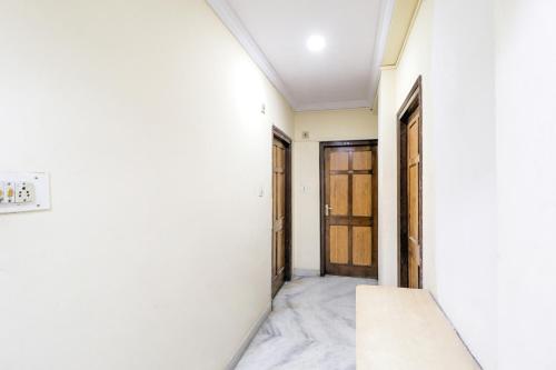 那格浦尔SPOT ON Hotel Sanskriti的一条带白色墙壁和门的走廊