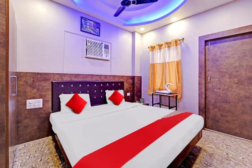 巴特那Flagship Saharsh Hotel的一间卧室配有一张带红色枕头的大床